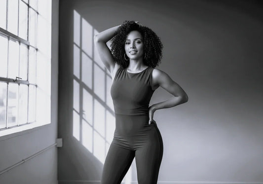 Realistic photographic image of a confident Afro-Latina model in a vibrant form-fitting dress, showcasing a perfectly sculpted hourglass silhouette, achieved with Sonryse Colombian Fajas.